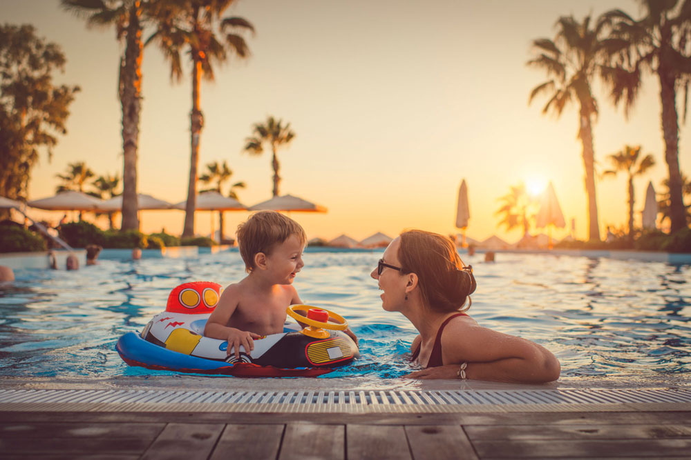 En mamma och ett barn badar i en pool